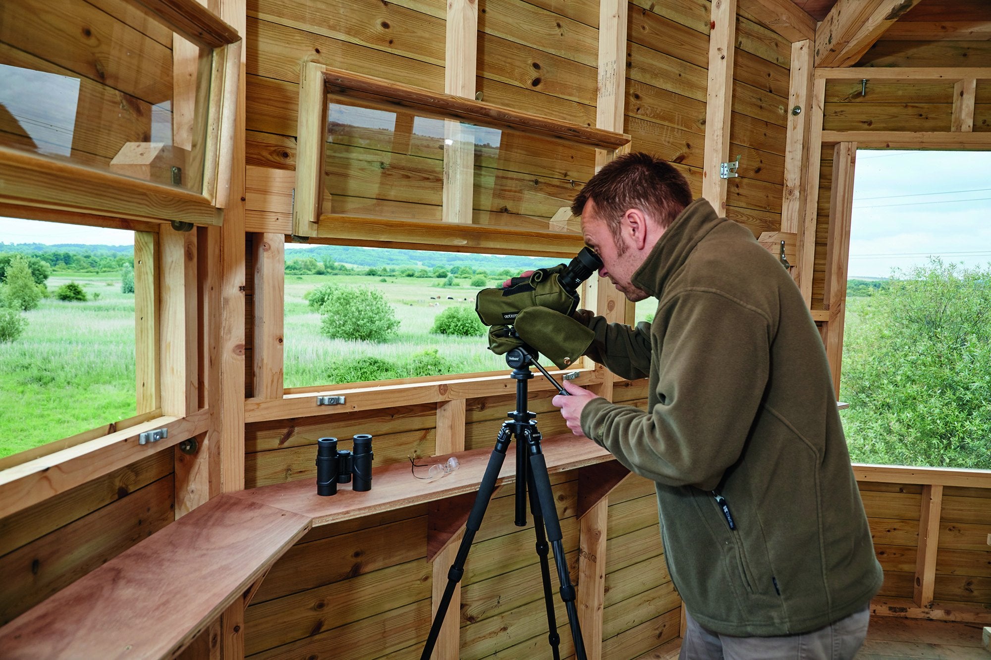 Man looking through spotting scope on tripod