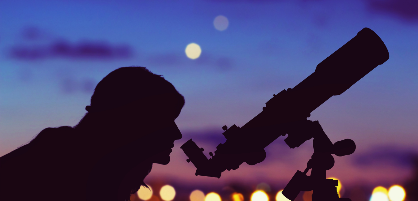 Man looking through telescope at night