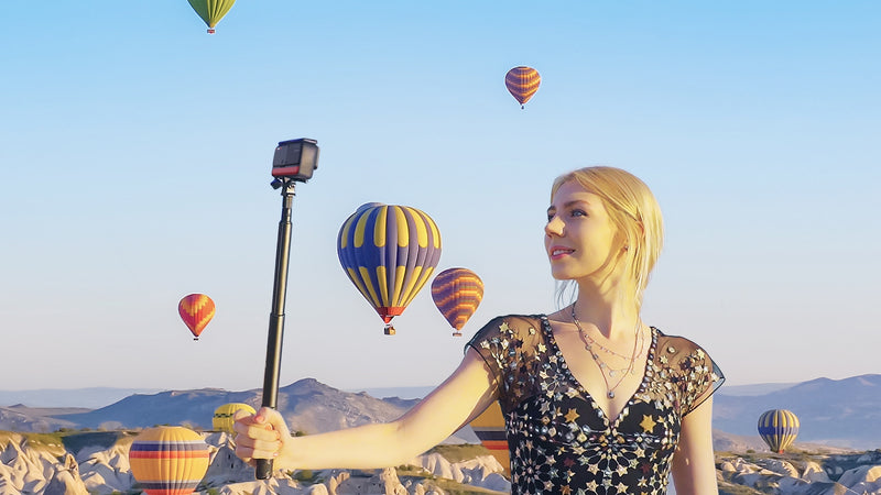 Insta360 ONE R Twin Edition - girl taking a selfie with hot air balloons in sky