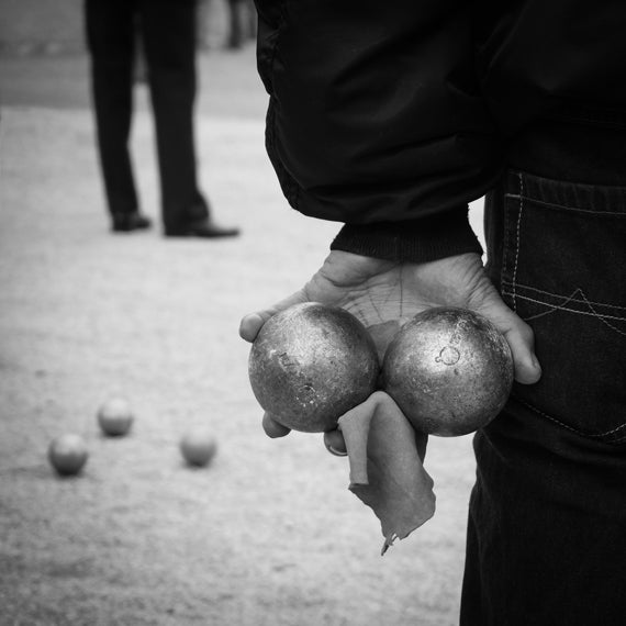 Black and white image of hand holding bowls balls