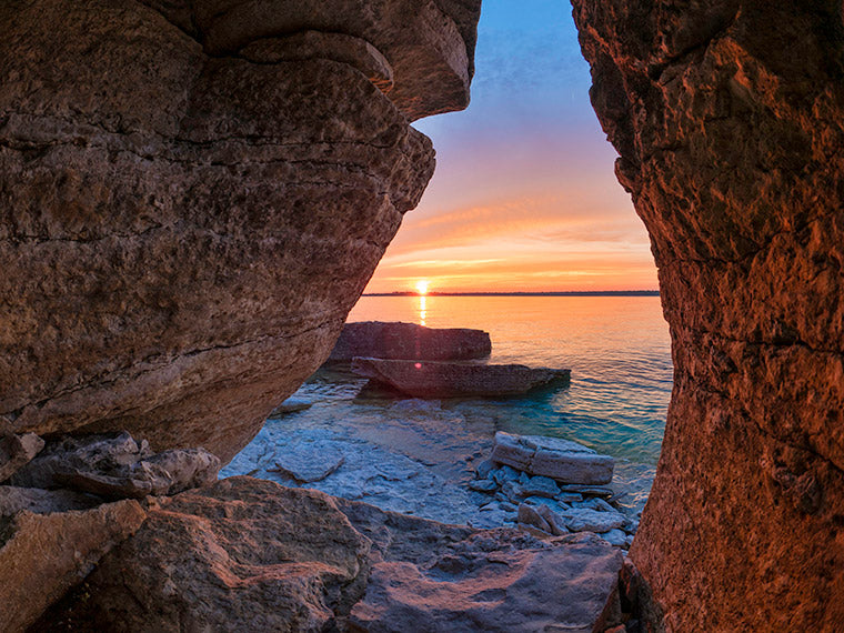 View of sunset and sea through rocks